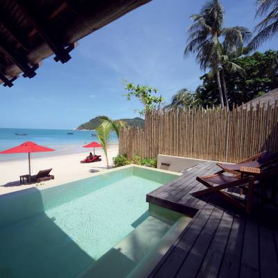 a wooden bench sitting next to a palm tree