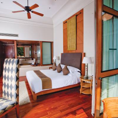 a bedroom with a bed and a chair in a room