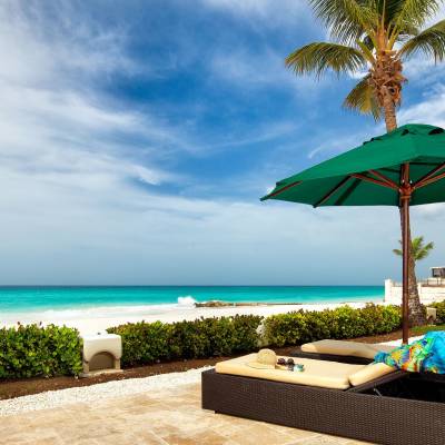 a couple of lawn chairs sitting on top of a sandy beach