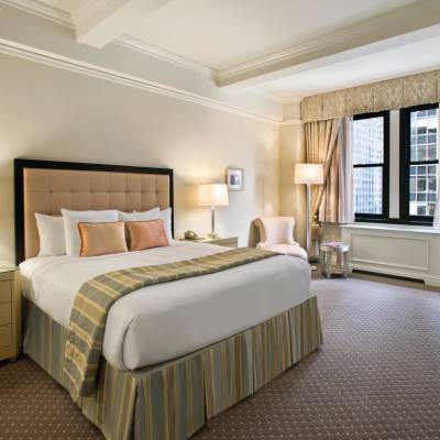a bedroom with a bed and desk in a hotel room