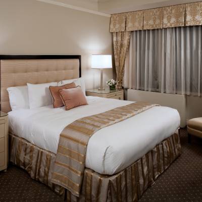 a bedroom with a bed and desk in a hotel room
