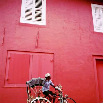 a red bicycle is parked on the side of a building