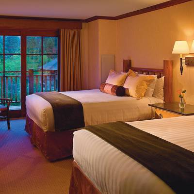 a bedroom with a bed and desk in a hotel room