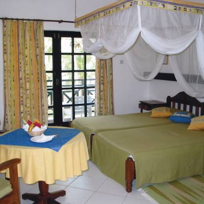 a bedroom with a bed and a chair in a room