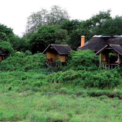 a house in the middle of a lush green field
