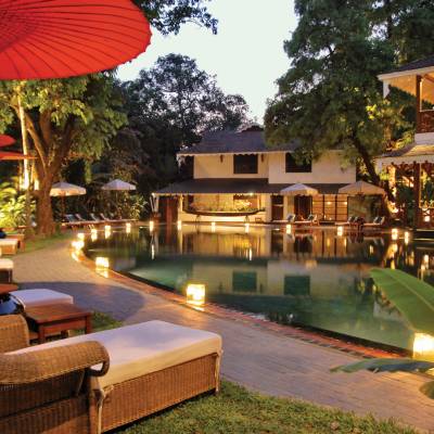 a group of people sitting at a table with a red umbrella