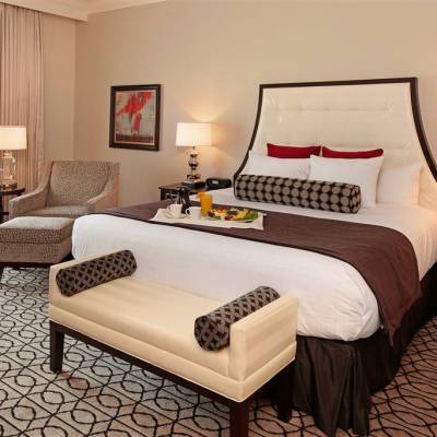 a bedroom with a bed and desk in a hotel room