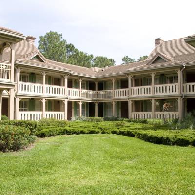 a large lawn in front of a house with Melrose Plantation in the background