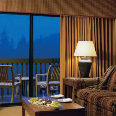 a hotel room with a couch a table and looking at the camera