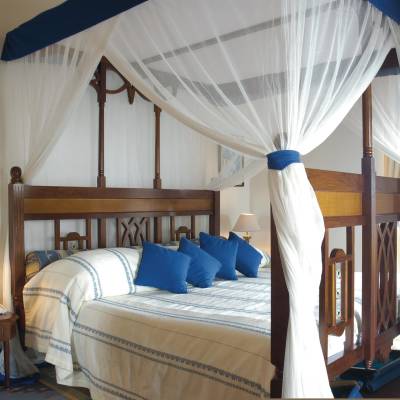 a bedroom with a bed and a chair in a room