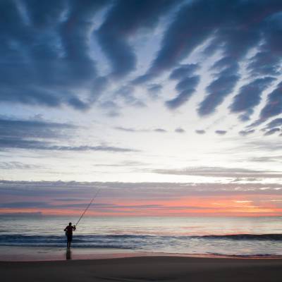 a man flying a kite on the beach