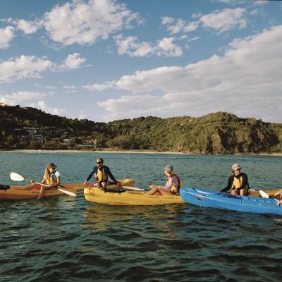 a group of people rowing a boat in a body of water