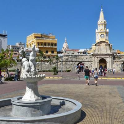 a group of people walking in front of a statue