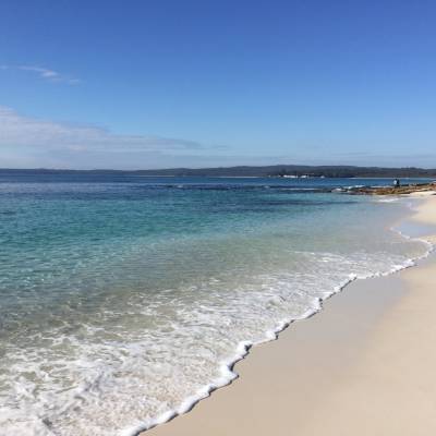 a sandy beach next to a body of water