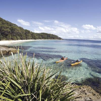 a sandy beach next to a body of water