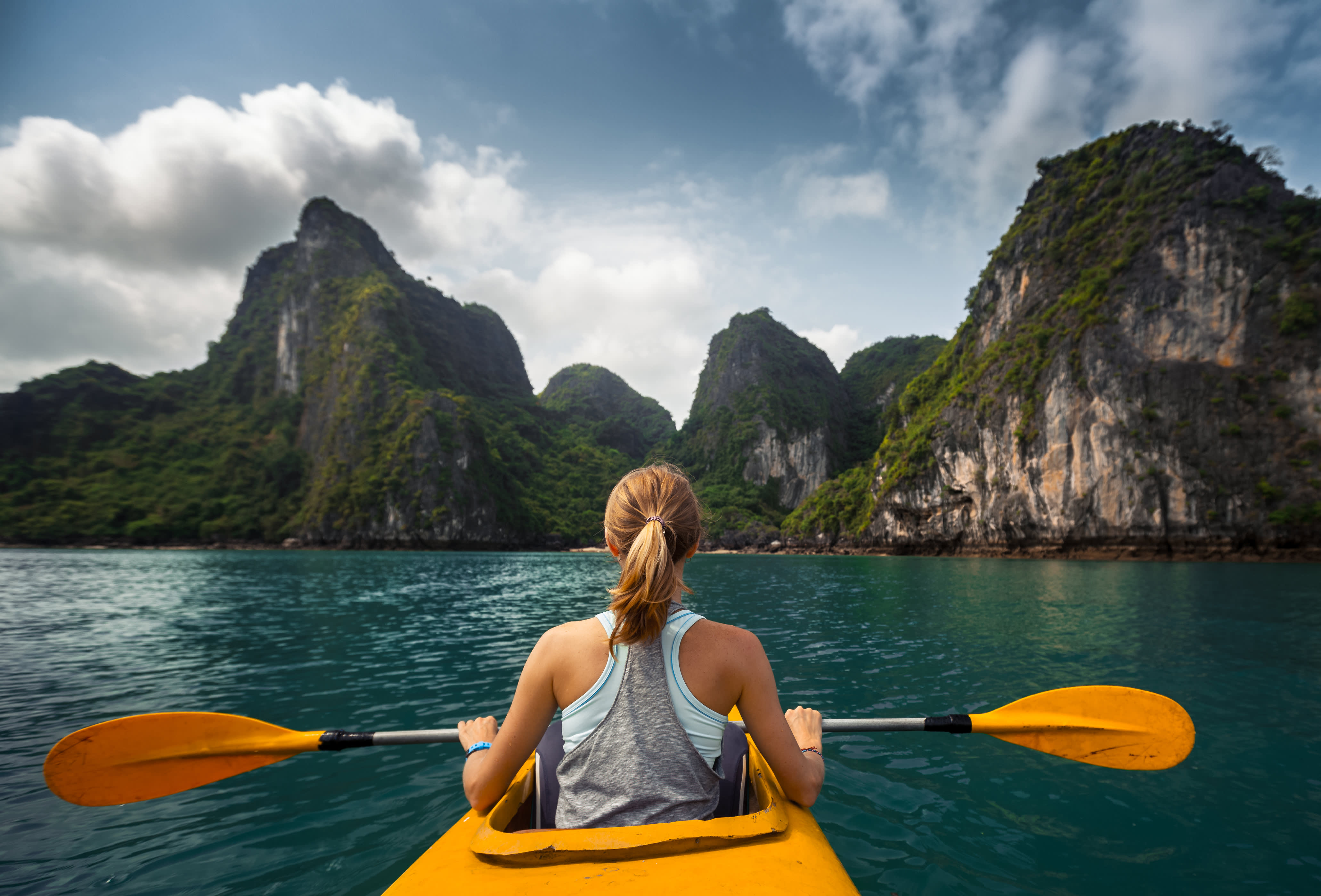 Woman exploring Ha Long Bay, Vietnam by kayak.