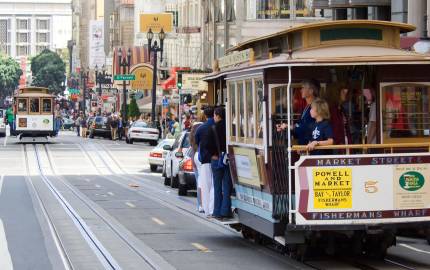 a person riding on the back of a truck on a city street