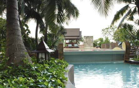 a large pool of water in front of a palm tree