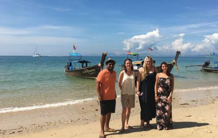 a group of people standing on top of a sandy beach