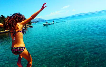 a woman standing next to a body of water