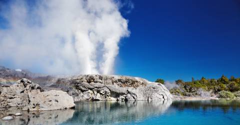 Pohutu Gejser vid blå sjö i Rotorua på Nordön, Nya Zeeland