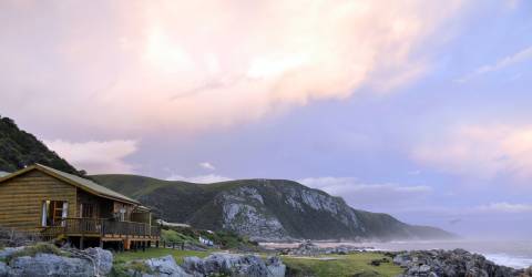 Trähus på klippor med utsikt över havet vid Plettenberg Bay, Sydafrika