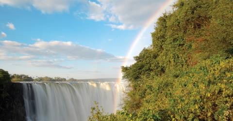 Färgglad regnbåge som går ner över Victoriafallen, Zimbabwe