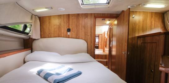 Ruime dubbele hut aan boord van de Grand Classique, met warme houten elementen, comfortabel beddengoed en natuurlijk licht dat binnenkomt via een groot zijraam.