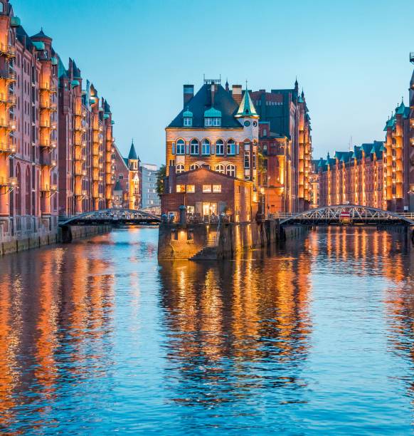 Classic view of famous Speicherstadt warehouse district, a UNESCO World Heritage Site since 2015, illuminated in beautiful post sunset twilight at dusk, Hamburg, Germany