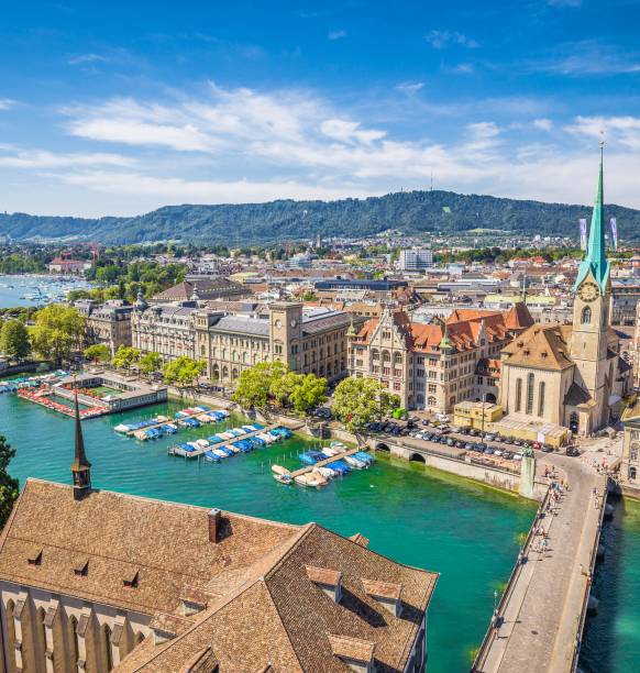 Aerial view of historic Zurich city center with famous Fraumunster Church and river Limmat at Lake Zurich from Grossmunster Church on a sunny day with clouds in summer, Canton of Zurich, Switzerland