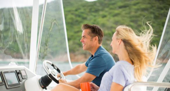 Couple enjoying the wind in their hair while cruising on a power catamaran