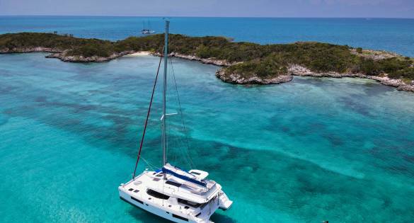 Sunsail catamaran on turquoise water with people swimming nearby