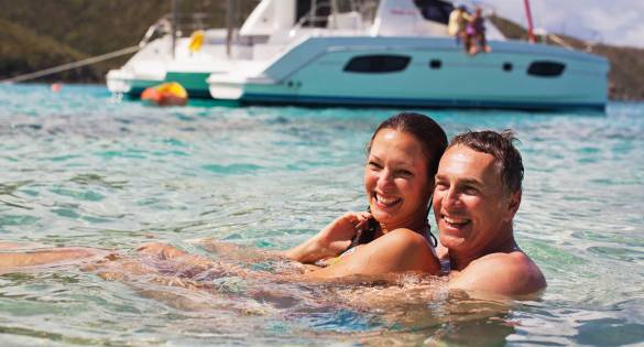 couple-swimming-infront-of-yacht
