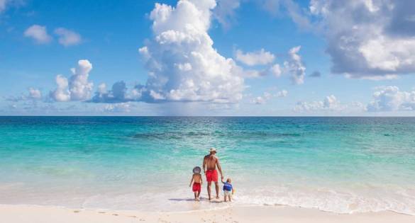 Father and sons walking on beach