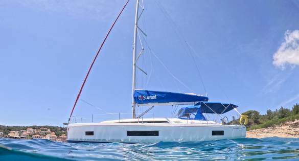 split image of a Sunsail yacht and person swimming below the ocean surface