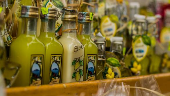 Enchanting Travels Italy Tours Small limoncello bottles for sale in a souvenir shop in Italy; typical Italian souvenir; lemon liquor