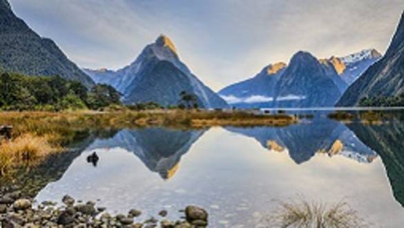 Enchanting Travels New Zealand Tours First light on Mitre Peak and surrounding mountains at Milford Sound