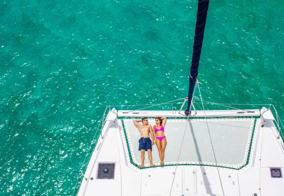 Couple sunbathing on a catamaran