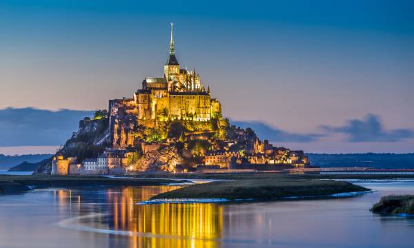 Beautiful view of famous Le Mont Saint-Michel tidal island in beautiful twilight during blue hour at dusk, Normandy, northern France