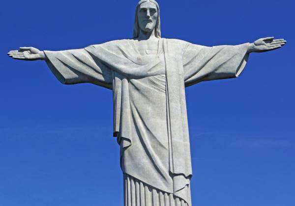 a statue of a clear blue sky with Christ the Redeemer in the background