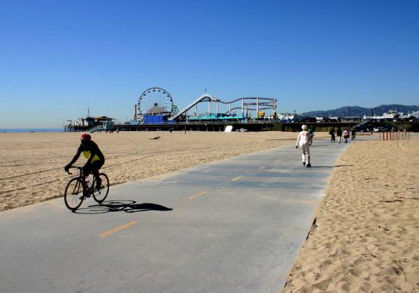 a person riding a bicycle on a sandy beach