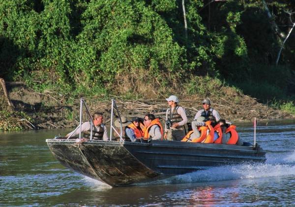 a group of people riding on the back of a boat in the water