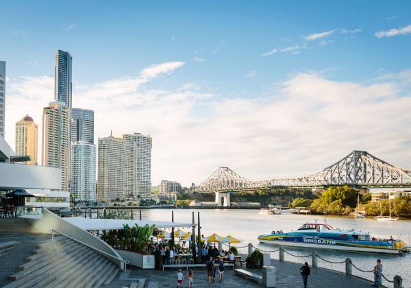 a bridge over a body of water with a city in the background