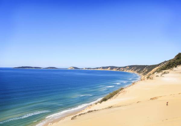 a sandy beach next to a body of water