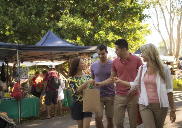 a group of people standing next to a person at a park