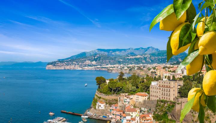 Aerial view of cliff coastline Sorrento and Gulf of Naples, Italy. Ripe yellow lemons in foreground. In Sorrento lemons are used in production of limoncello.
