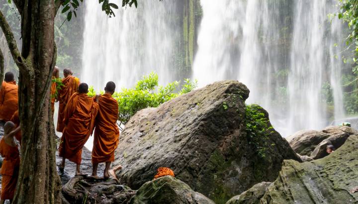 Group of young buddhist monks enjoying the view of Kulen Waterfall in Cambodia, Asia