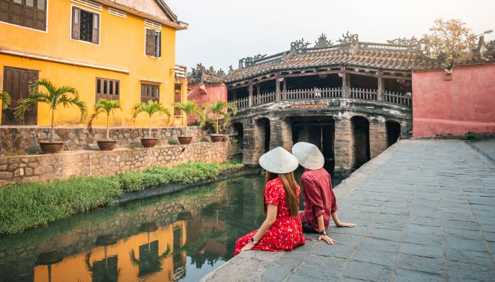 Travel couple with Japanese Covered Bridge, in Hoi An, Vietnam, Asia