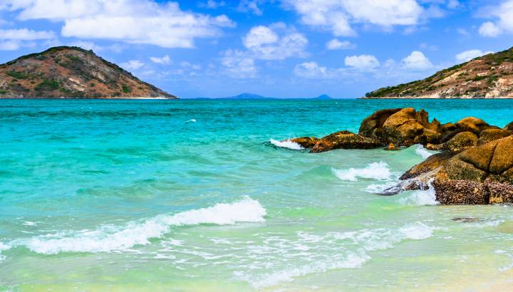 Enchanting Travels -Clear blue waters lapping on coastal rocks at Blue Lagoon on Lizard Island, Queensland