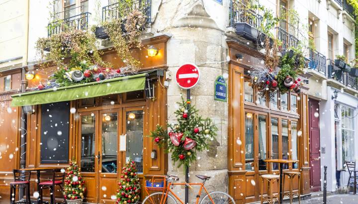 Enchanting Travels France Tours Bicycle is parked at typical Parisian cafe decorated for Christmas